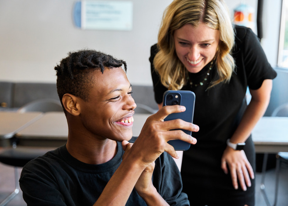 Participant Lance Gladney shows teacher Lauren Mehalek a photo he took on his iPhone.