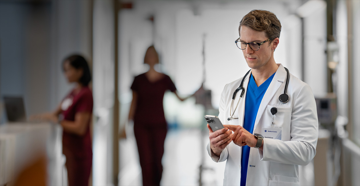 M?t nam bác s? ?ang nhìn vào iPhone trong b?nh vi?n.