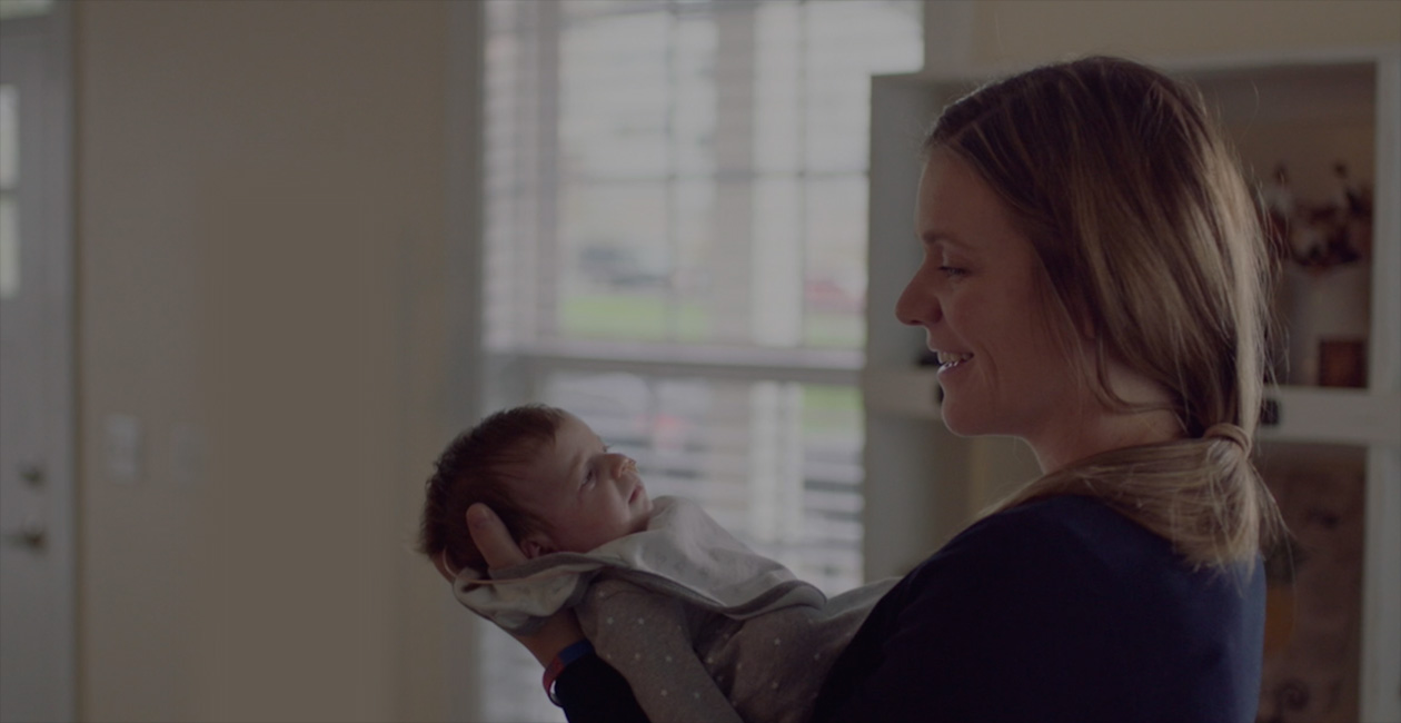 A mother smiling at her new baby.